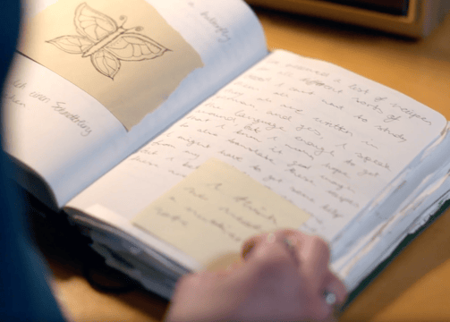 a person holding a book with a butterfly on it