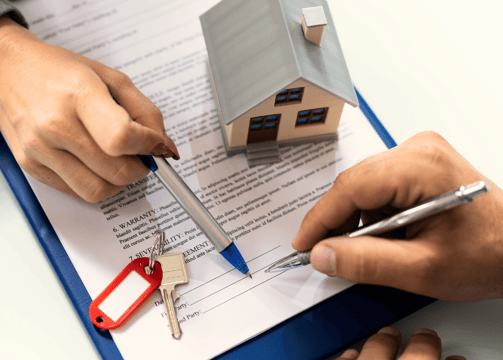 a person holding a pen and writing on a clipboard