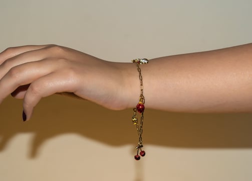 a woman's hand holding a bracelet with a chain link bracelet