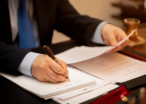 a man in a suit jacket and tie dyes a pen and a pen