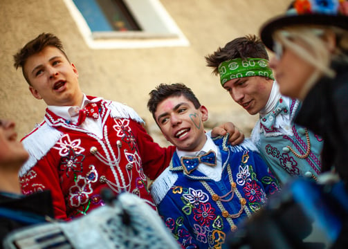 a group of people dressed in costumes and singing during carnival