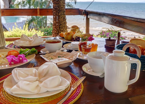 a table with plates of food and a cup of coffee