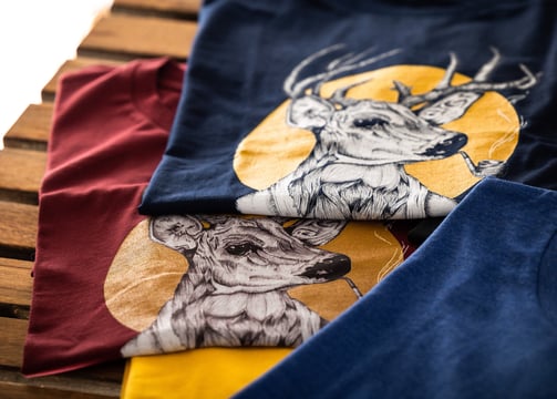 Two graphic t-shirts featuring a stylish deer smoking a pipe, printed design