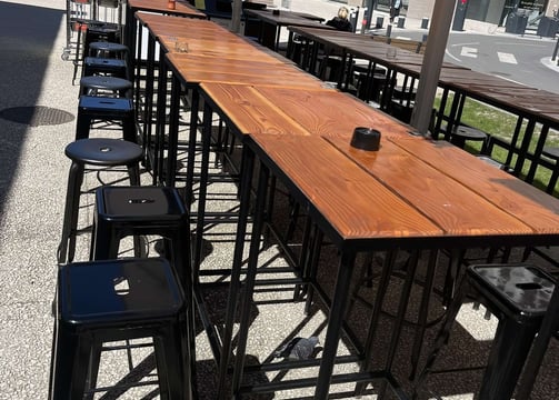 Mobilier de terrasse sur mesure pour les Halles de la Cartoucherie à Toulouse, tables hautes en bois et structures métallique