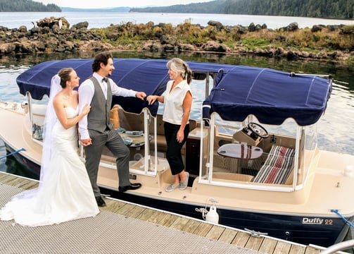 a bride and groom standing on an eco-friendly all electric boat wedding anniversary proposal
