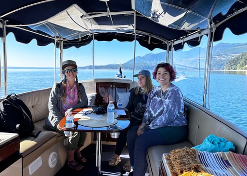 a group of people sitting on an eco-friendly all electric boat clients team building