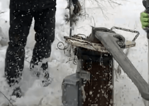 Large wrench opening well head in winter.