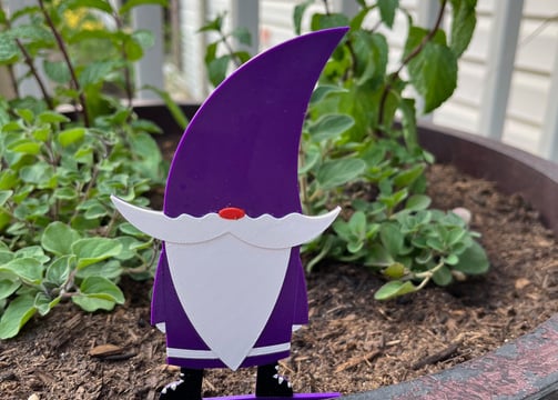 purple plastic gnome in a flower pot
