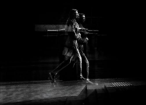 Two people walking, distorted through glass. The Usher Hall, Edinburgh