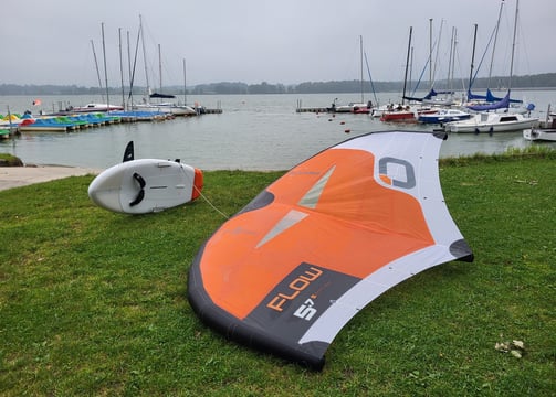 pompowana deska wingfoil i ozone wing na jeziorze Łąka, w tle port oraz jezioro idealne do wingfoila