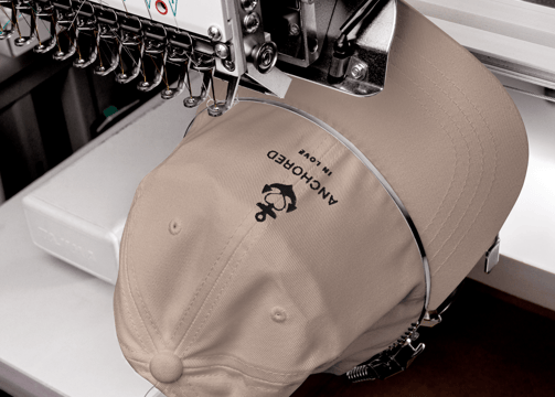 a beige cap being embroidered with anchor design