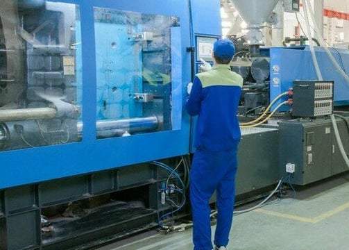 a man in a blue jumpsuit and a blue jumpsuit in a factory