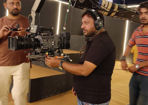 a man in a black shirt is holding a camera and a camera