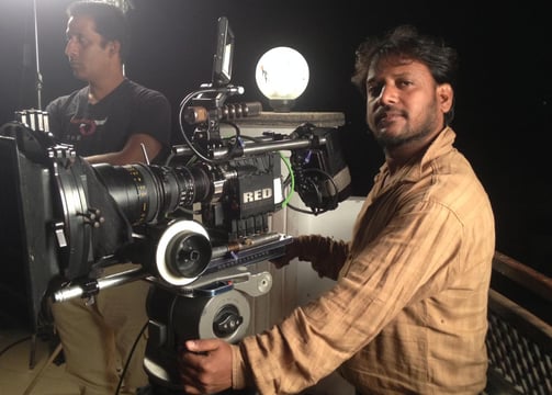 a man in a brown shirt is holding a camera