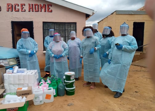 a group of people in protective clothing standing in front of a building