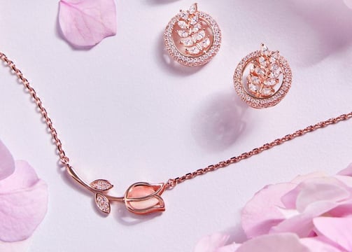 a pink rose gold jewelry set with a rose gold necklace and earrings