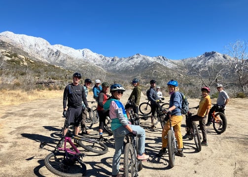 a group of people standing around a group of bikes