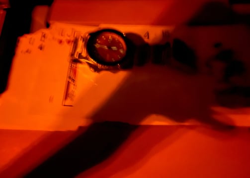 a person holding a clock and a clock on a table