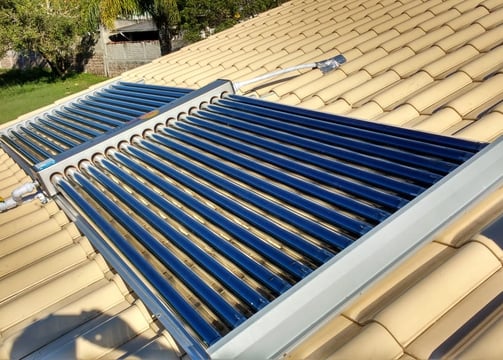 "Aquecedor solar de água instalado em telhado para uso residencial, utilizando energia solar térmica