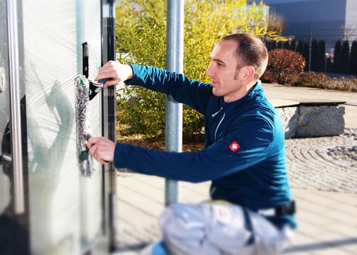 Ein Fensterputzer reinigt das Fenster. 