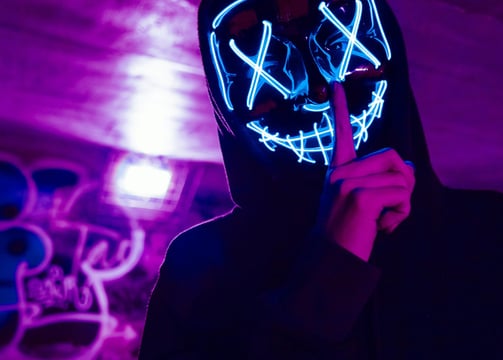 a person wearing a mask mask and a black hoodie
