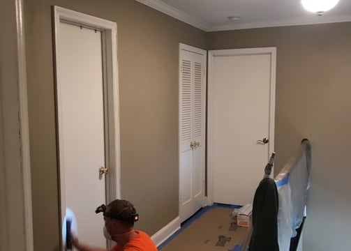 a man is painting a wall in a room