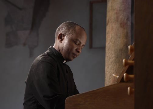 an african man from Tanzania plays the piano enjoing it