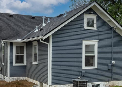 a house with a blue house with a black roof