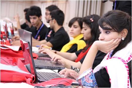 A diverse group of individuals collaborating at a table, each focused on their laptops, engaged