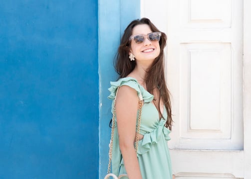 young woman wearing turquoise dress and sunglasses