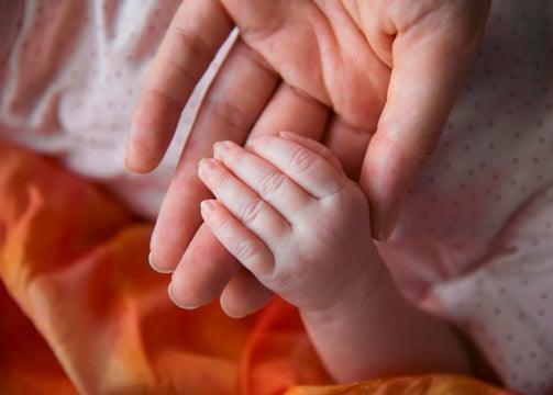 Mother holding a newborn baby's hand