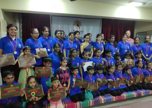 a group of people standing around a group of medals