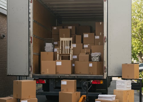 A box truck full of moving boxes and furniture.