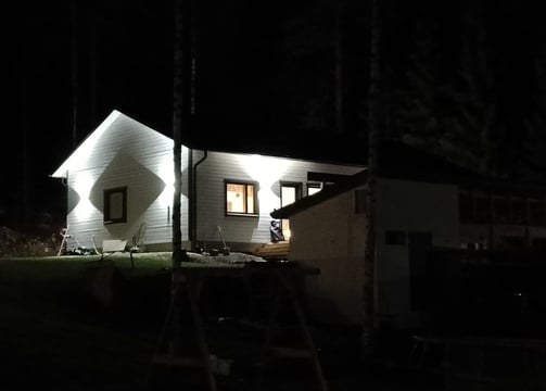 uusi talo jossa valot valaisevat taloa komeasti.