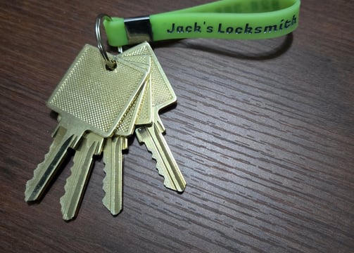 A Jack’s Locksmith green key ring with golden keys attached representing a master key lock system 