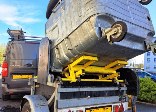 a trailer mounted bin cleaner with a commercial sized bin raised, ready for cleaning