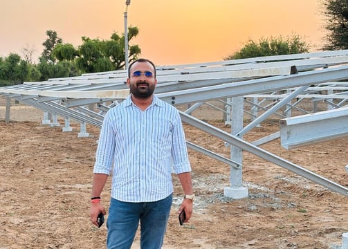 a man with a camera and a camera in front of a solar array