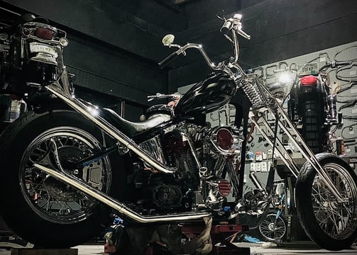 custom motorcycle parked on a lift inside of Schmidt Motos