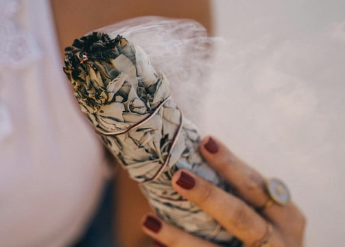 herbal smudge and a hand