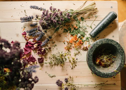 a mortar and herbs on the table