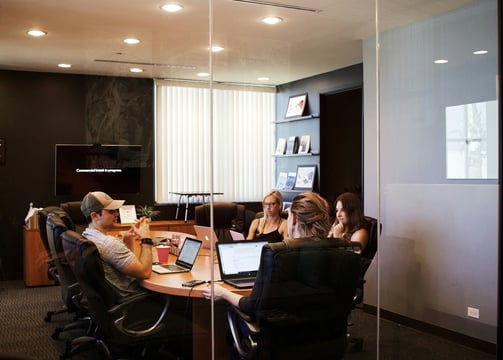 Four people in a conference room in a meeting. Photo by Campaign Creators on Unsplash