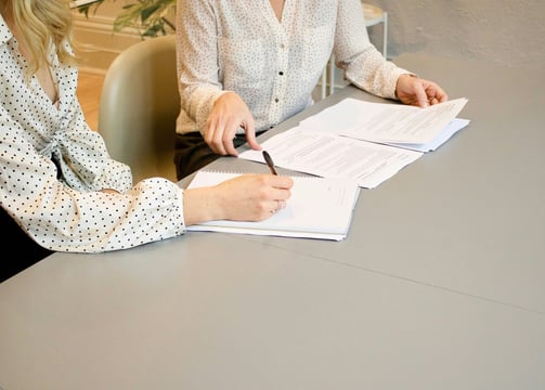 An image of two people working on paperwork. Photo by Gabrielle Henderson on Unsplash