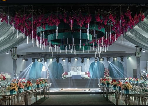 “White wedding stage decor with chandelier ceiling and floral table designs by Milano Event”