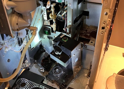 Internal view of a La Cimbali espresso machine with access to brew group and tubing system.