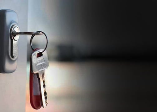 a key chain with keys on a door