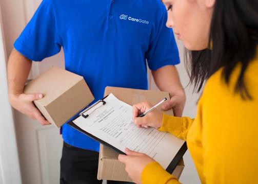 a man and woman holding boxes and a clipboard