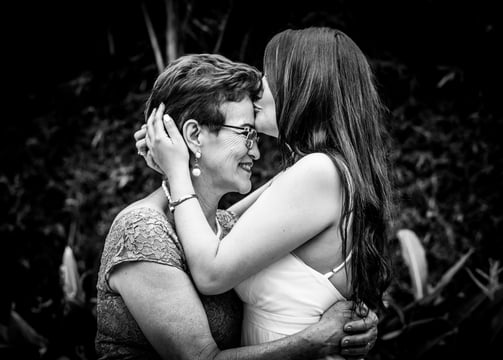 Novia el dia de su boda besando la frente de su madre