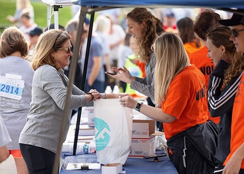 a photo of a runner completing their packet pickup to receive their race number