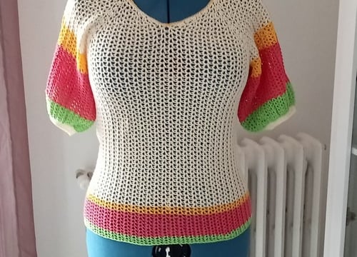 Pull crocheté dans des fils crème jaune rose et vert avec des manches courtes 