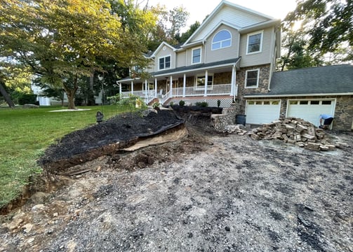a house with a pile of dirt on the ground
